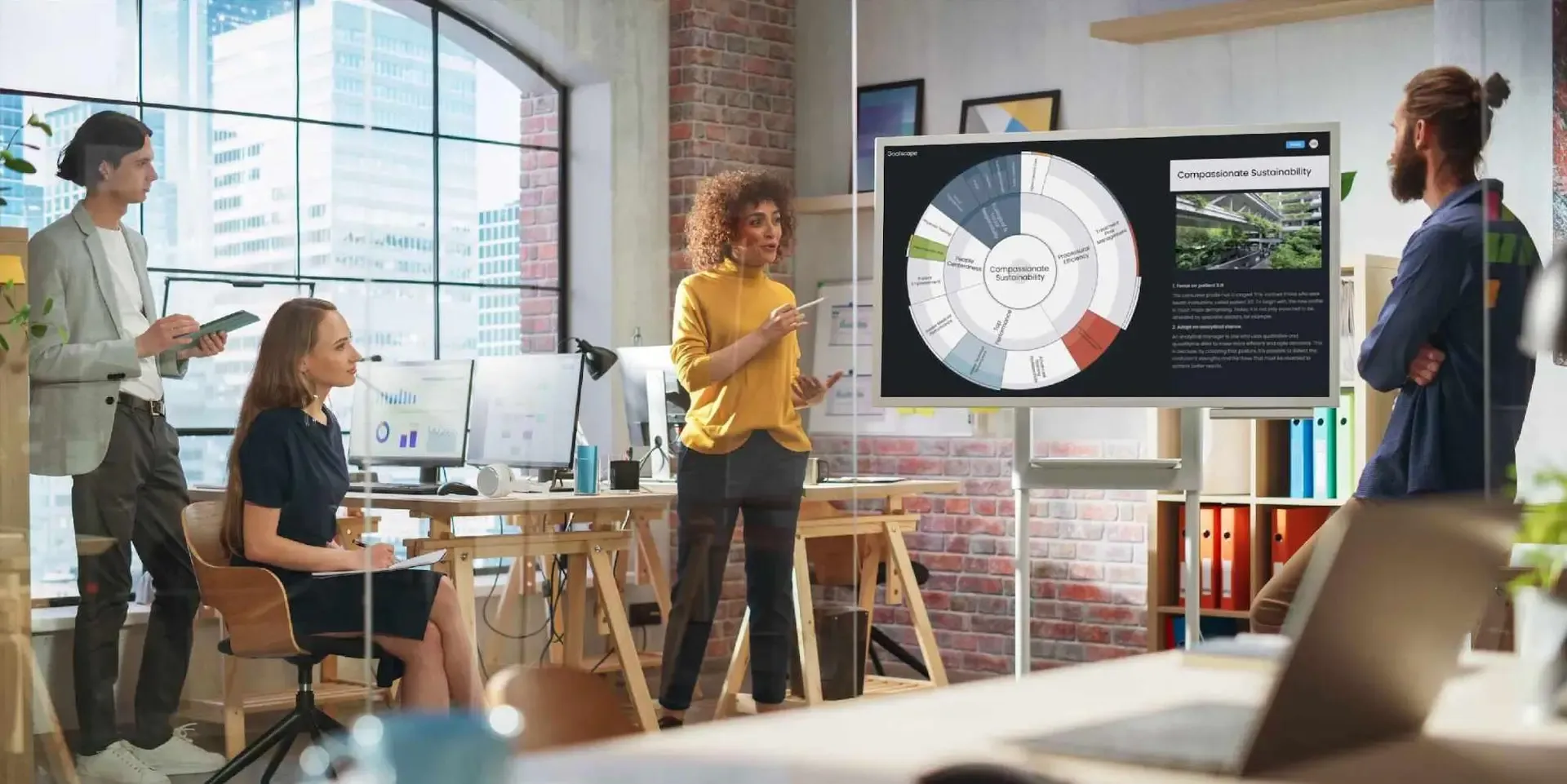 Un team che usa Goalscape in un ufficio luminoso, con una grande goal map di un progetto di sostenibilità empatica sulla parete